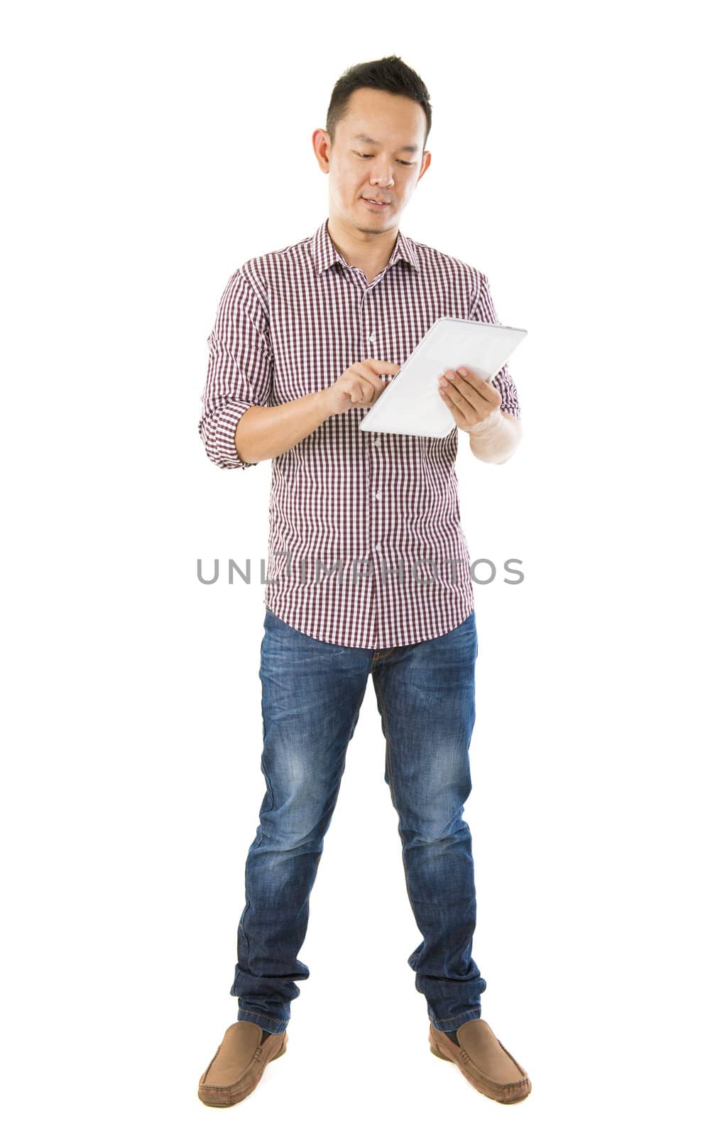 Fullbody Asian man using tablet computer standing over white background