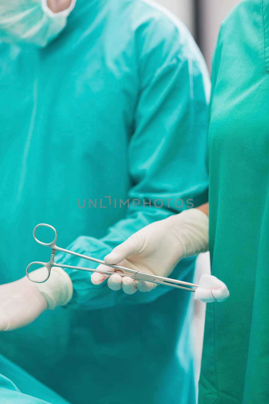 Close up of a surgical scissors holding by a nurse in an operating theatre