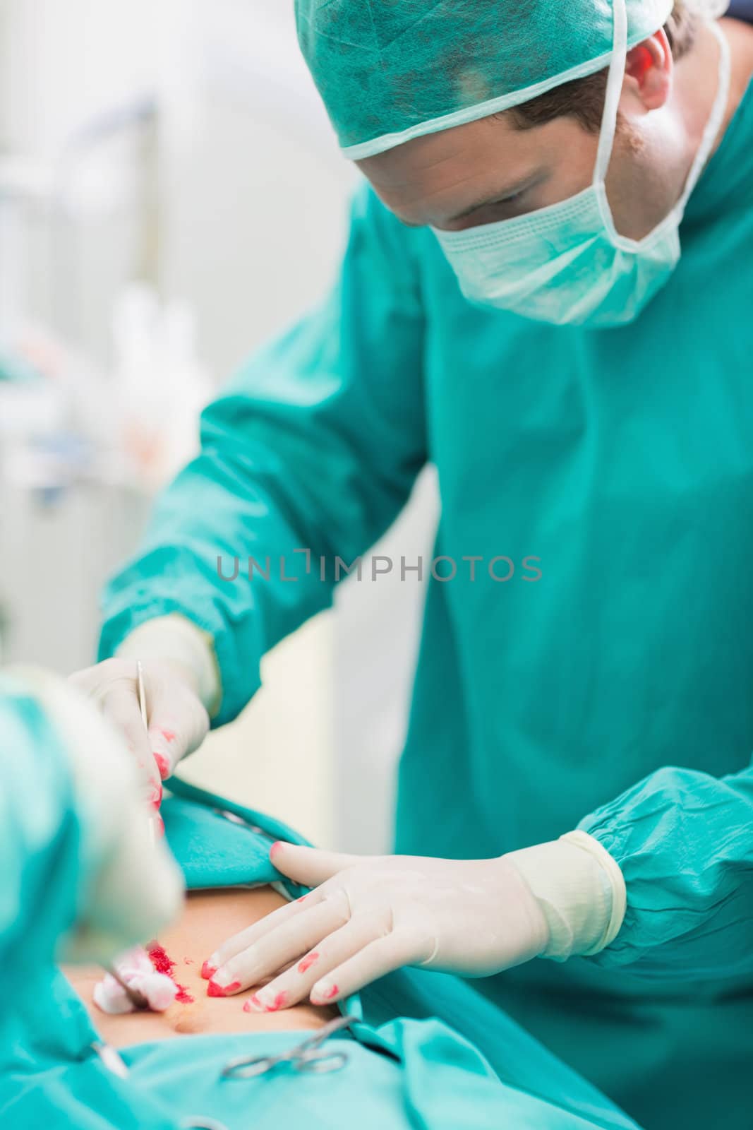 Surgeon touching at patient belly in an operating theatre