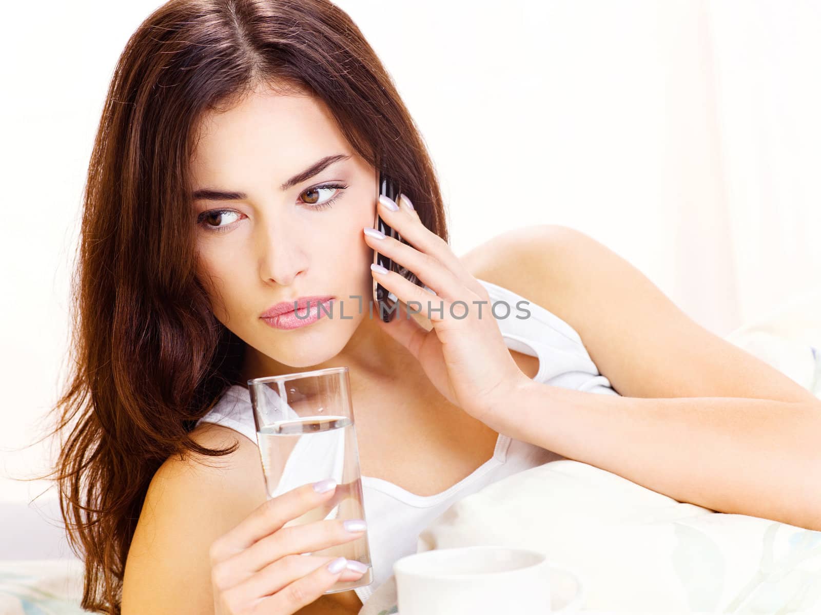 glass of water and phone in bed by imarin