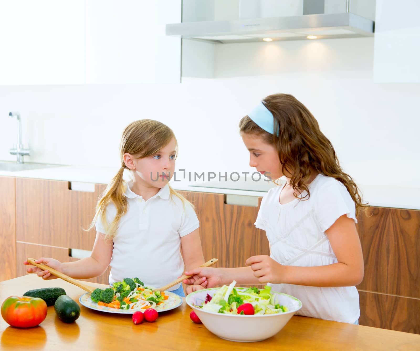 Beautiful chef sisters at home kitchen preparing salad