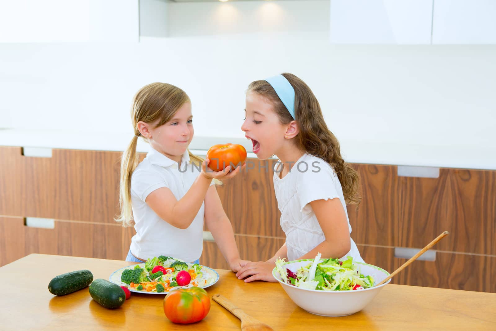 Beautiful chef sisters at home kitchen preparing salad