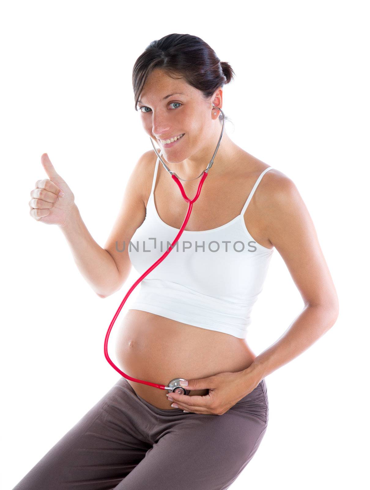 Beautiful pregnant woman as self doctor with stethoscope checking her belly
