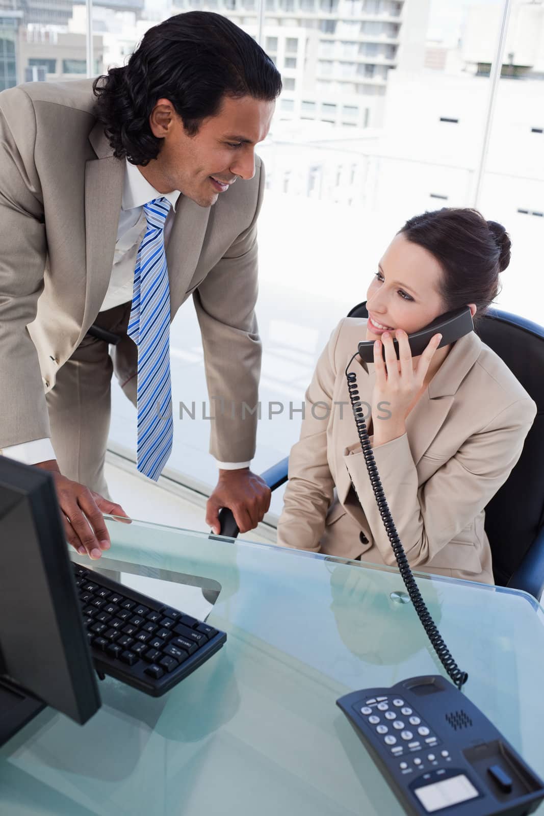 Portrait of a businesswoman on the phone while working with an employee in an office