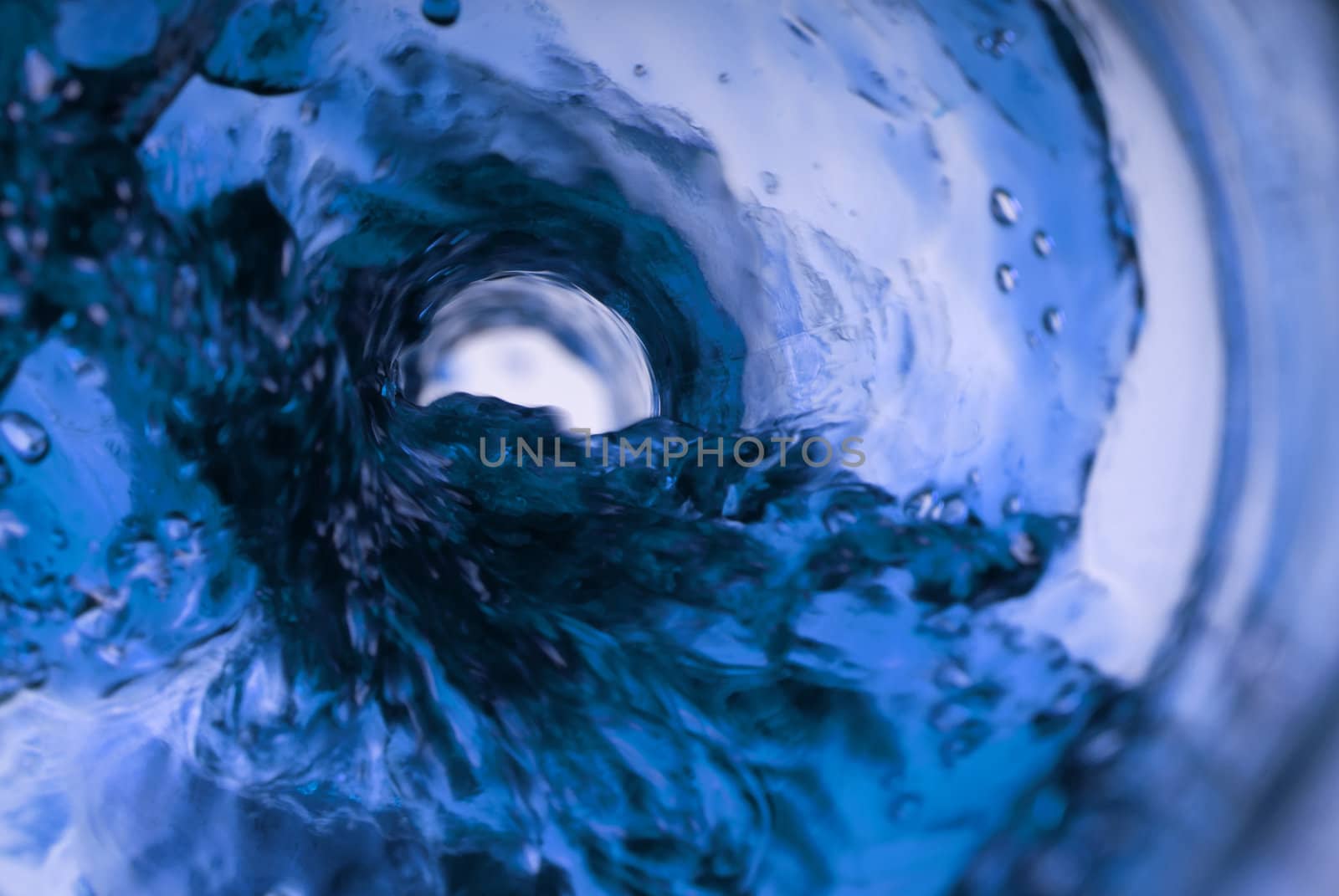 Whirlpool in blue from a glass bottle in studio