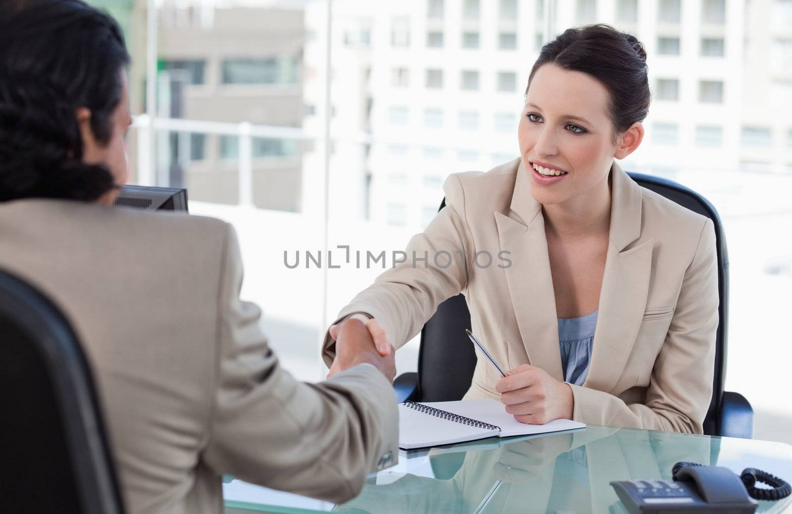 Manager shaking the hand of a male applicant in her office