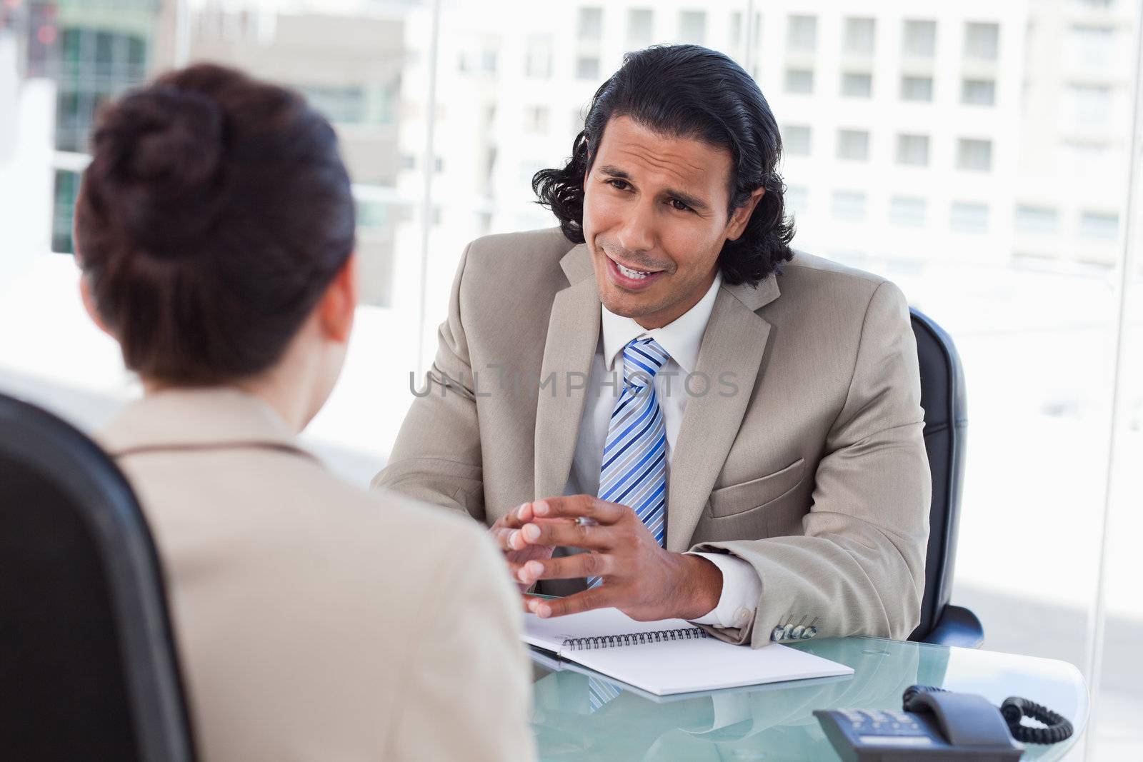 Smiling manager interviewing a female applicant in his office