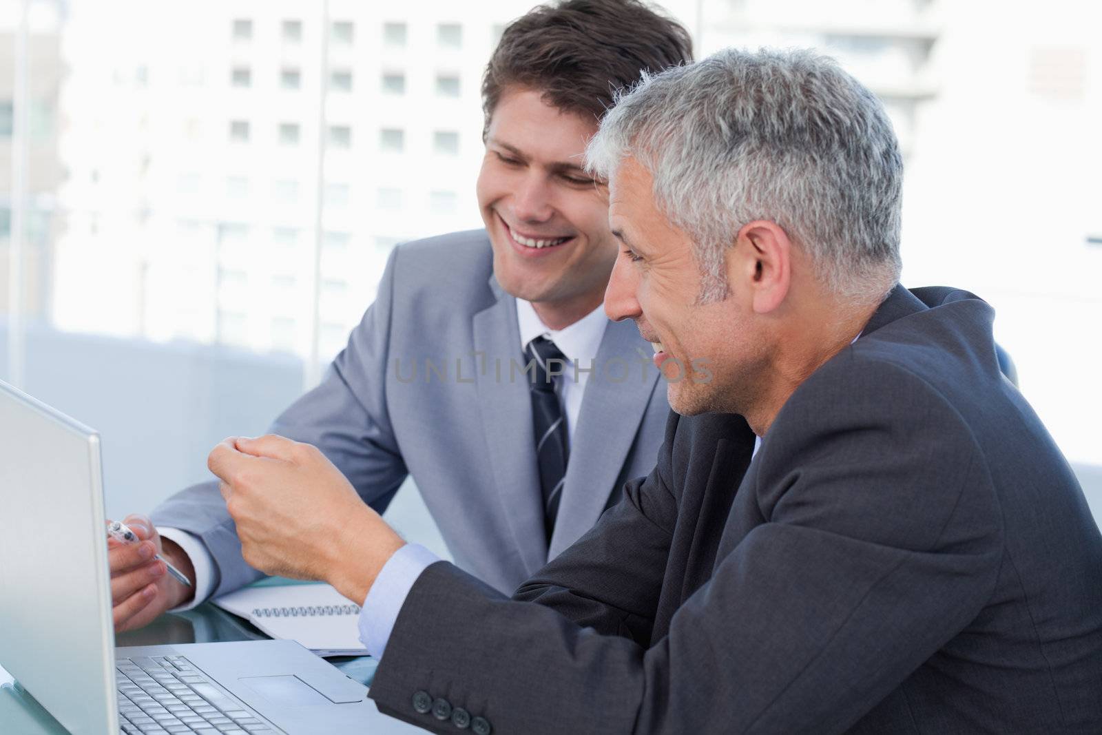 Businessmen working with a notebook in an office