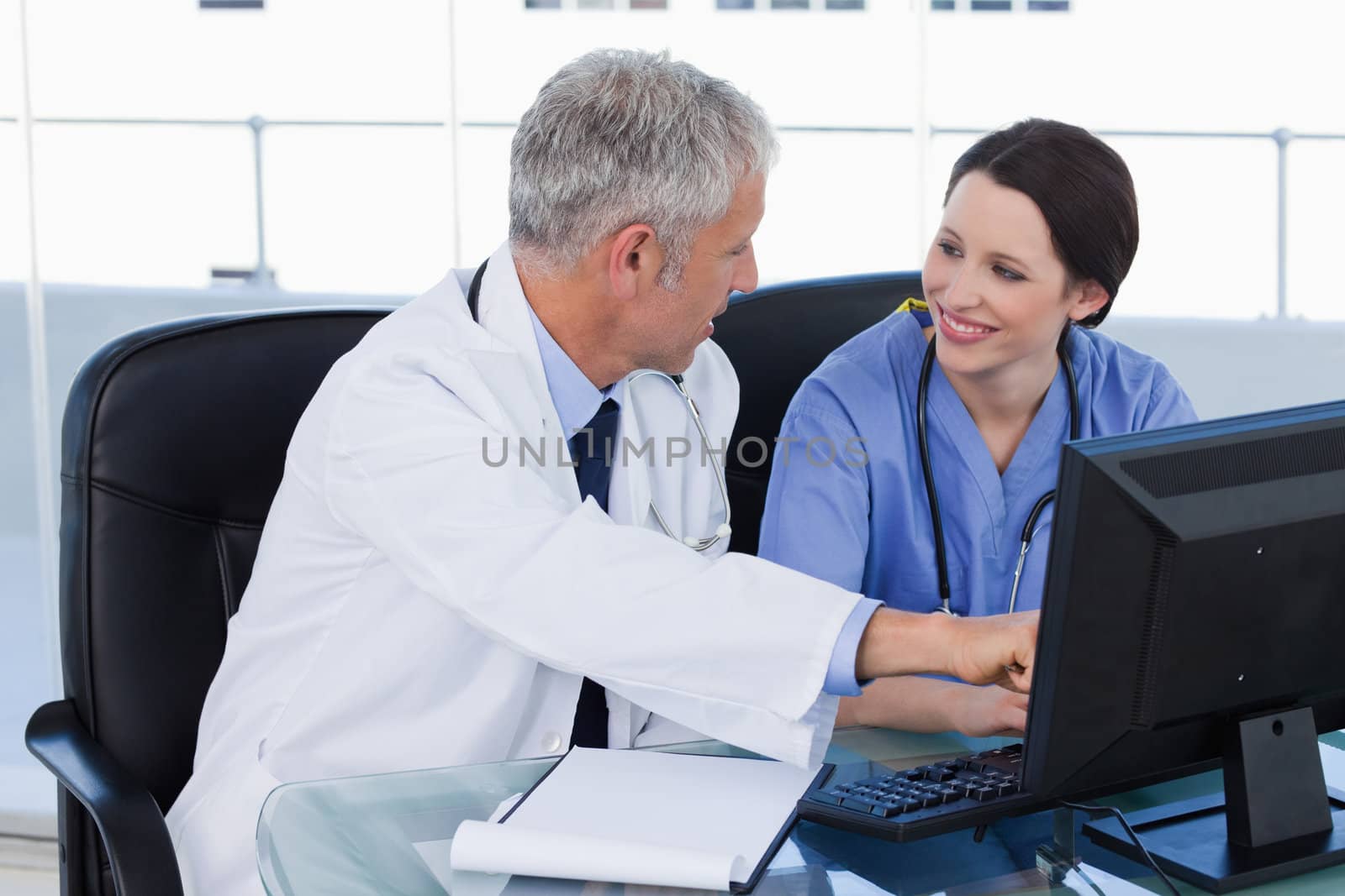 Smiling medical team working with a computer in an office