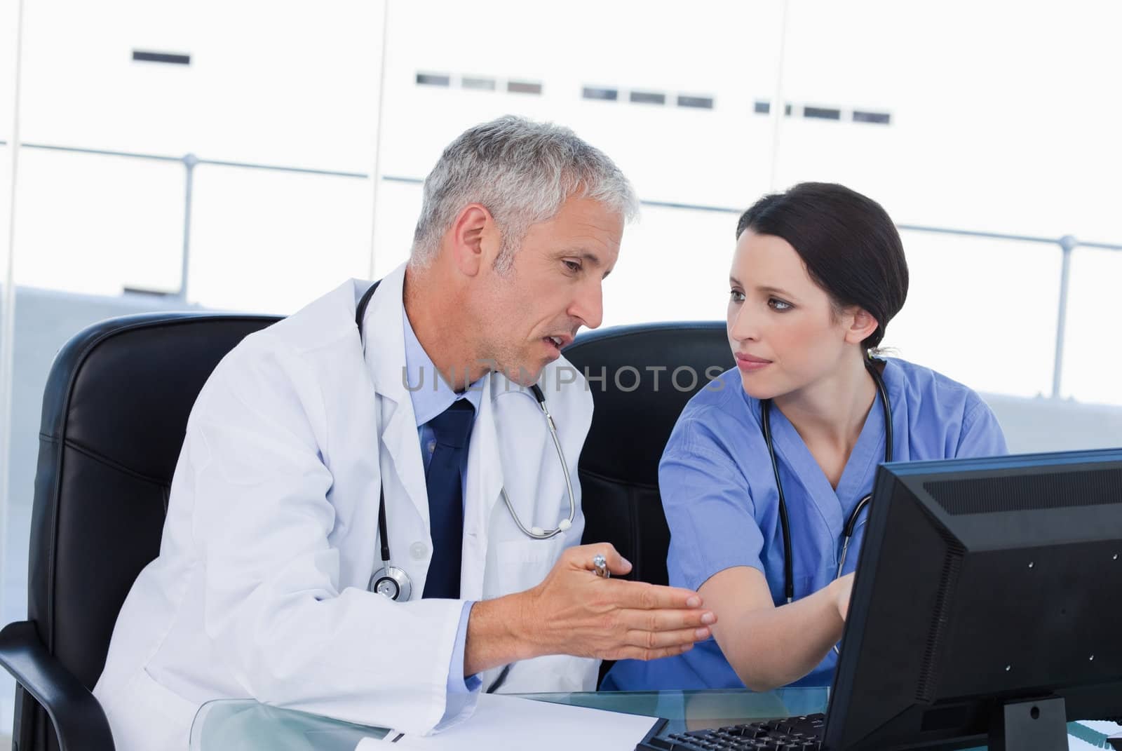 Serious medical team working with a computer in an office