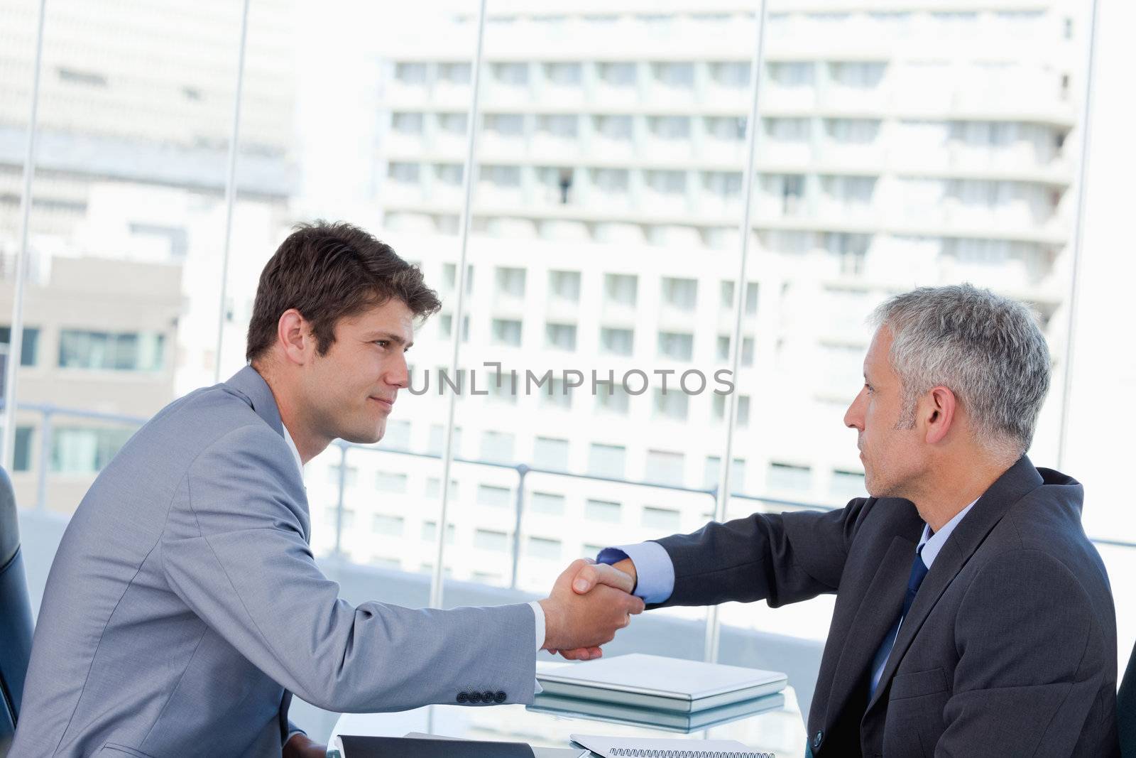 Serious businessmen shaking hands in an office