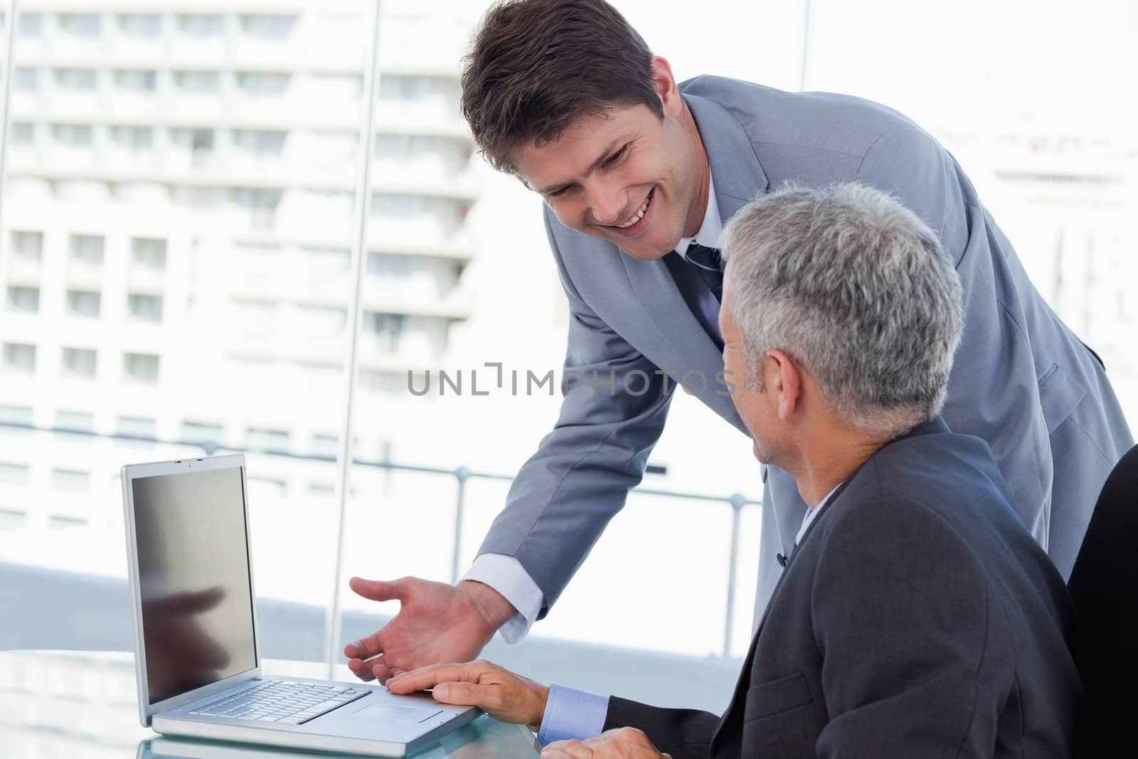 Side view of smiling businessmen working with a notebook in an office
