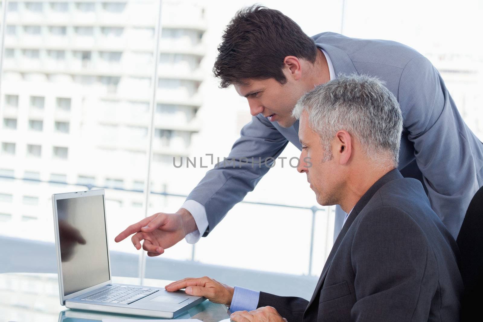 Side view of businessmen working with a notebook in an office