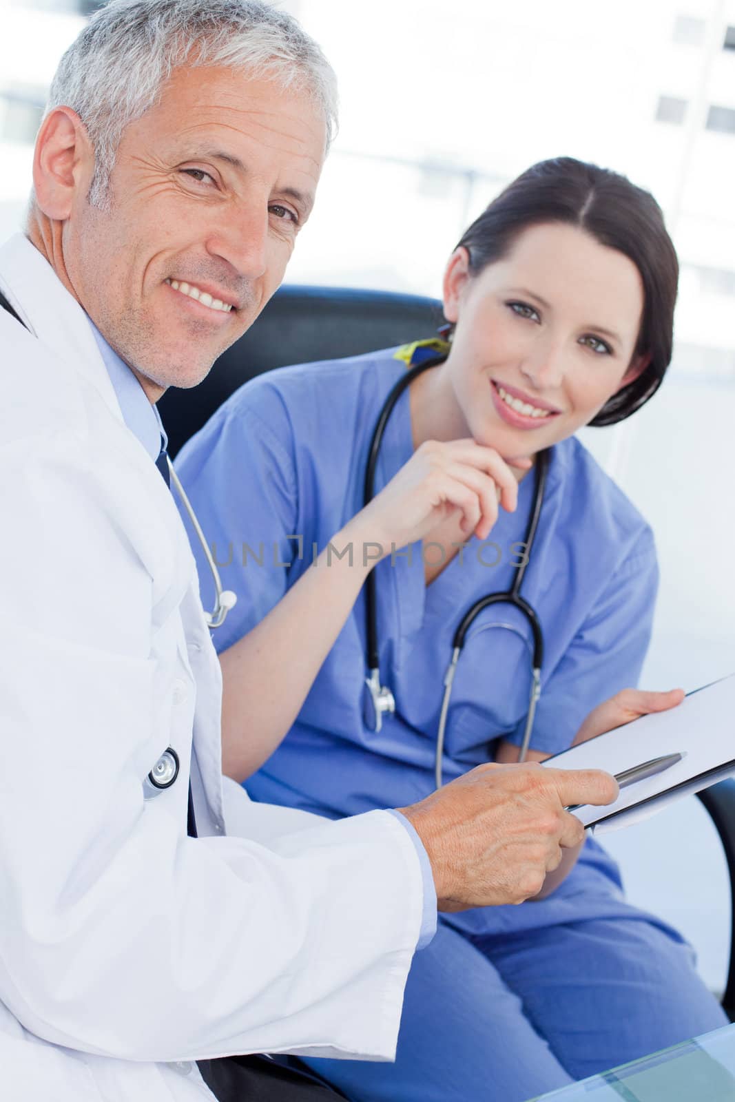 Portrait of a smiling medical team looking a document in an office