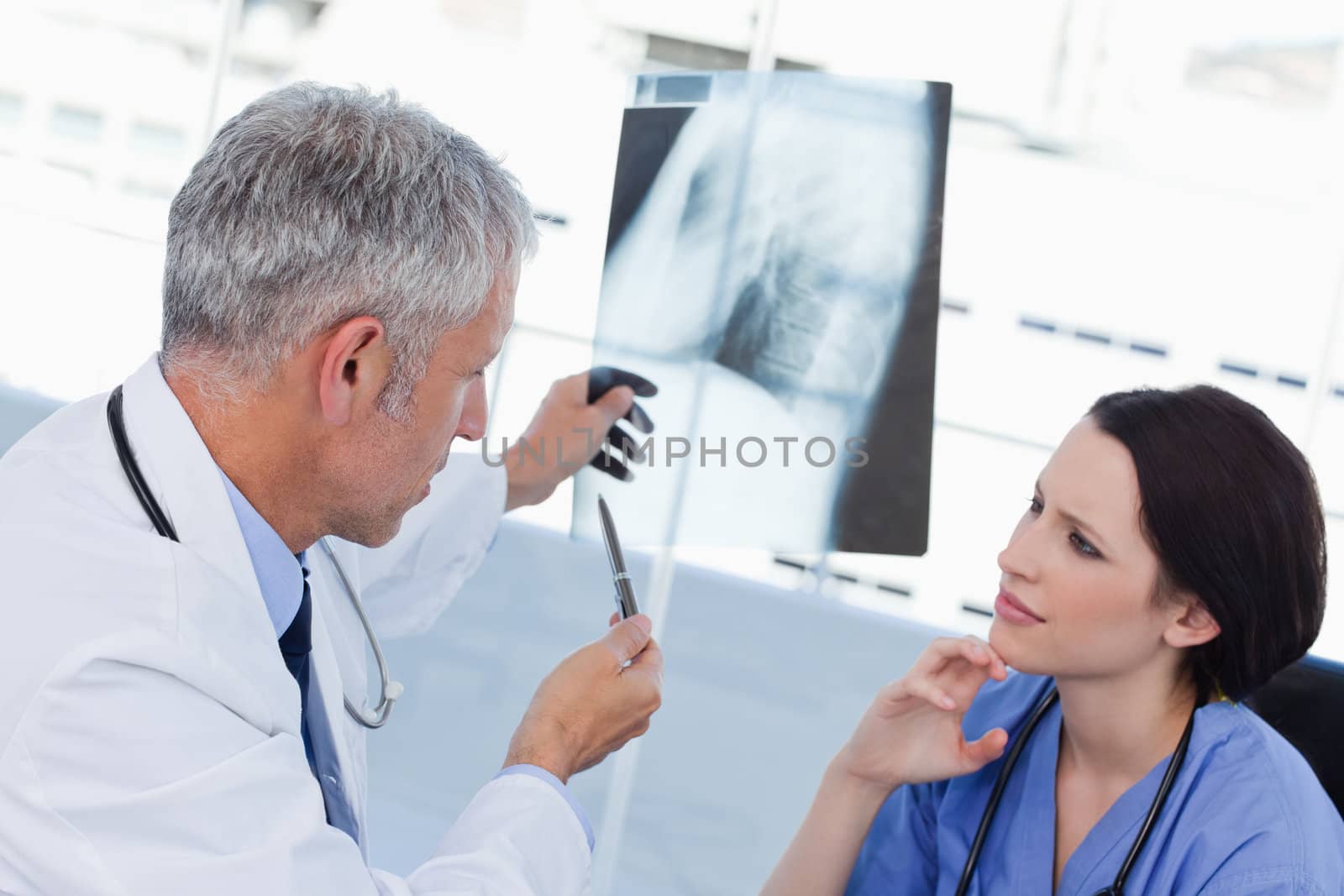 Serious medical team looking at a X-ray in an office