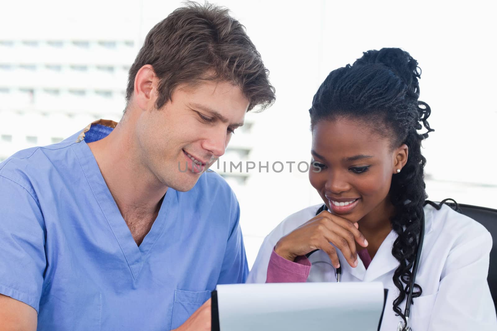 Happy doctors looking at a document in an office