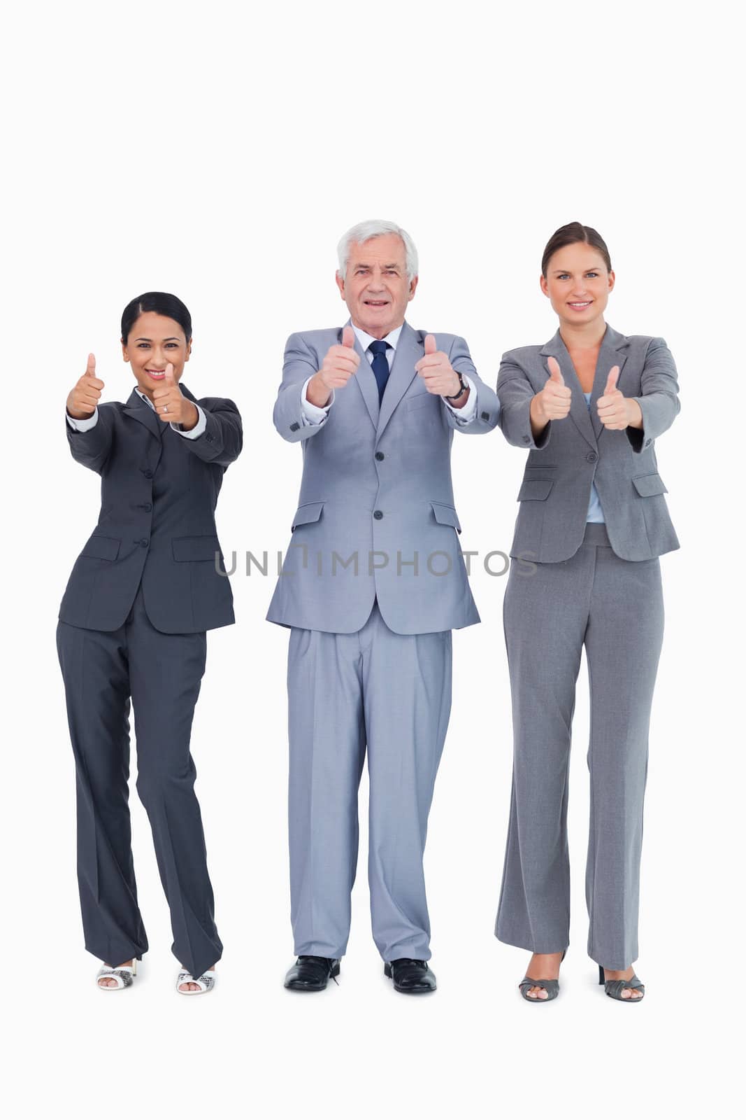 Three smiling businesspeople giving thumbs up against a white background