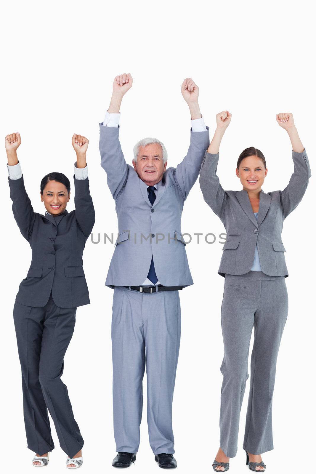 Three businesspeople with arms up against a white background