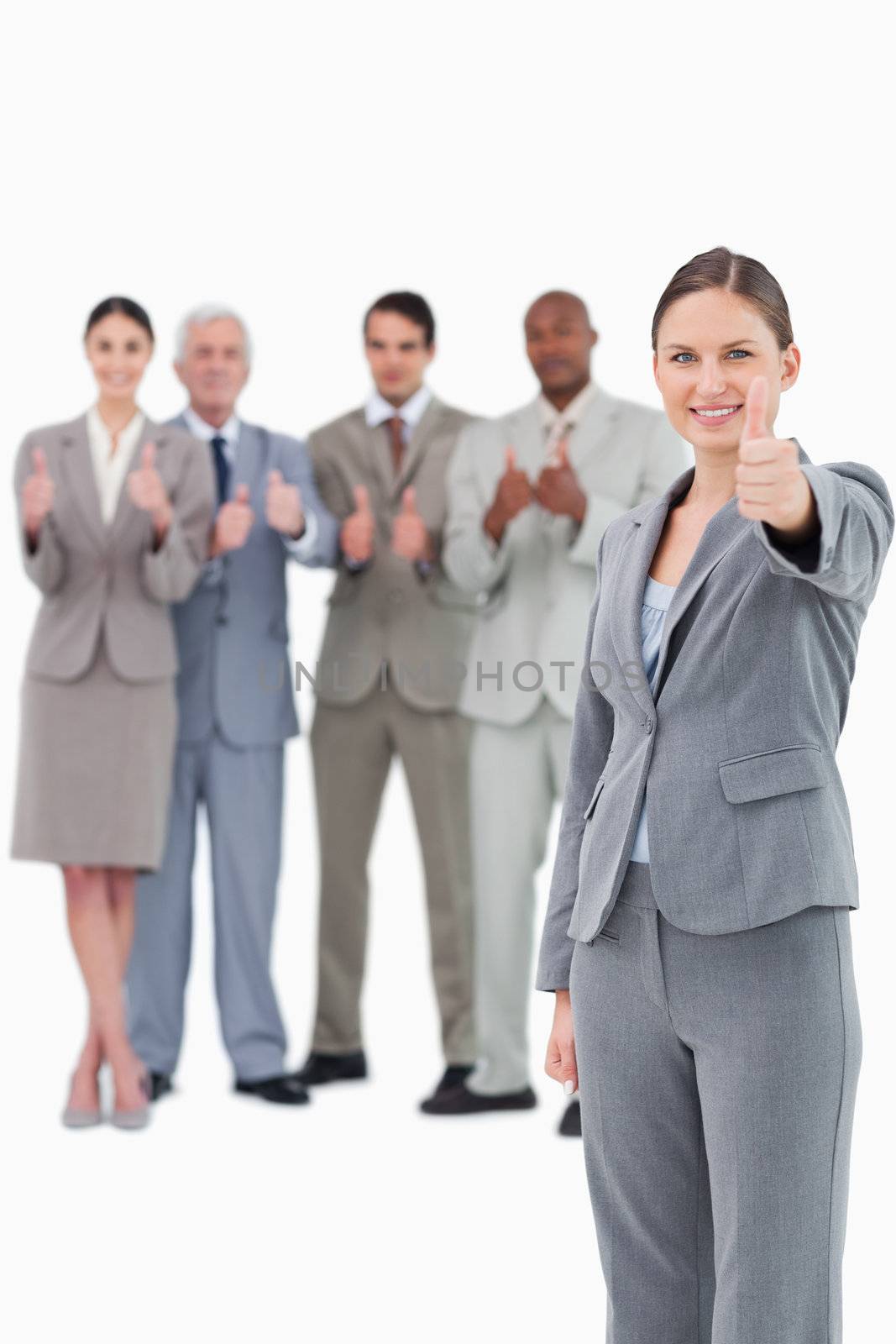 Saleswoman with thumb up and her team behind her against a white background