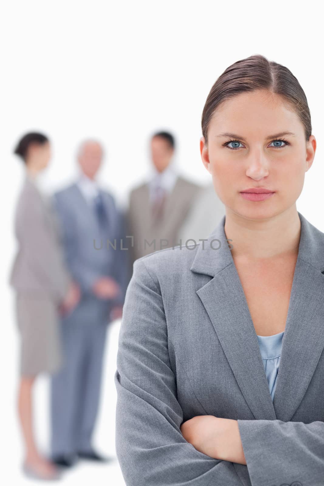 Serious businesswoman with her colleagues behind her against a white background