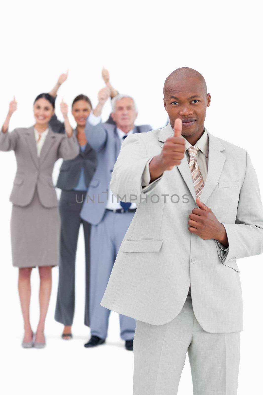 Tradesman with team behind him giving thumb up against a white background