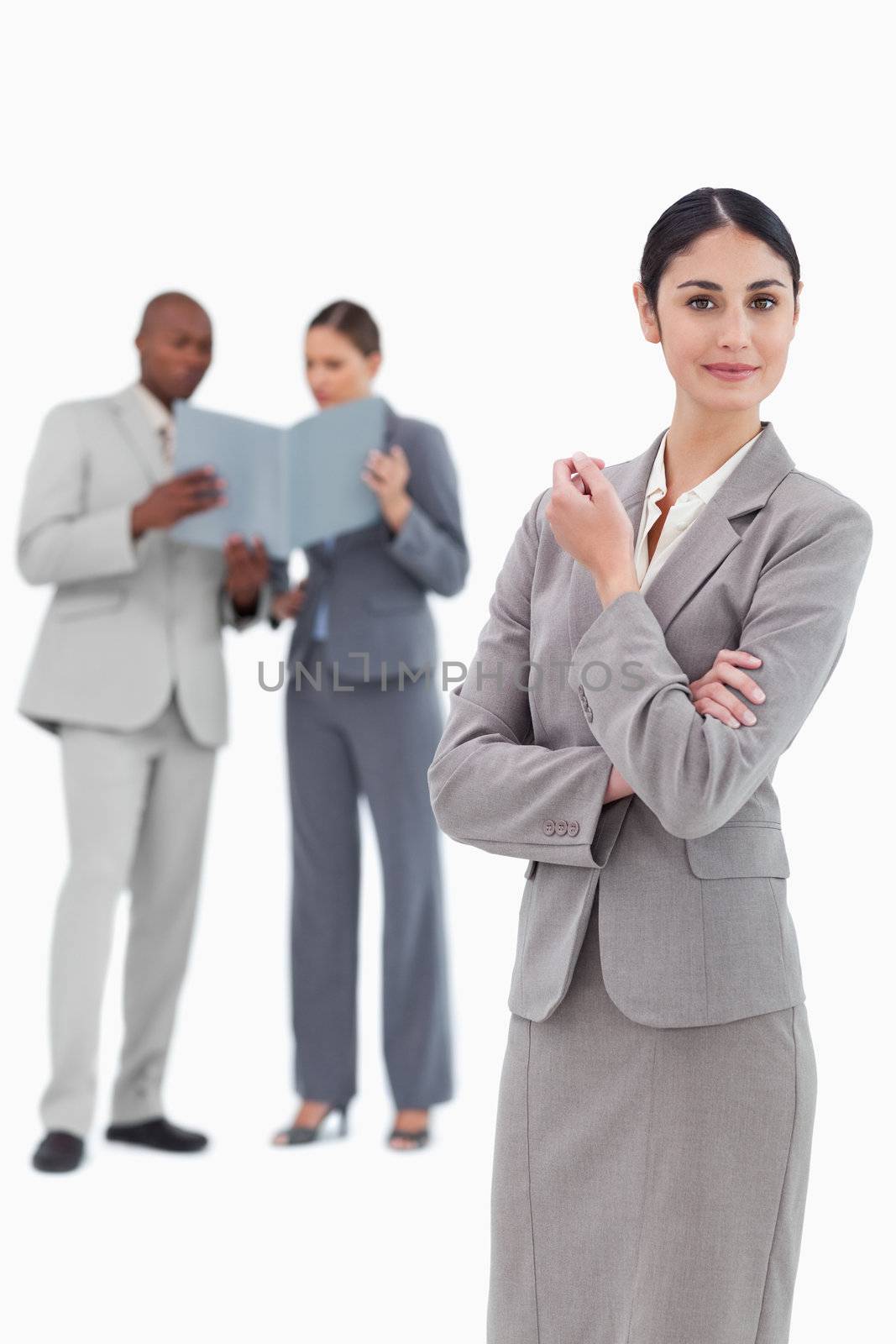 Saleswoman with co-workers behind her against a white background