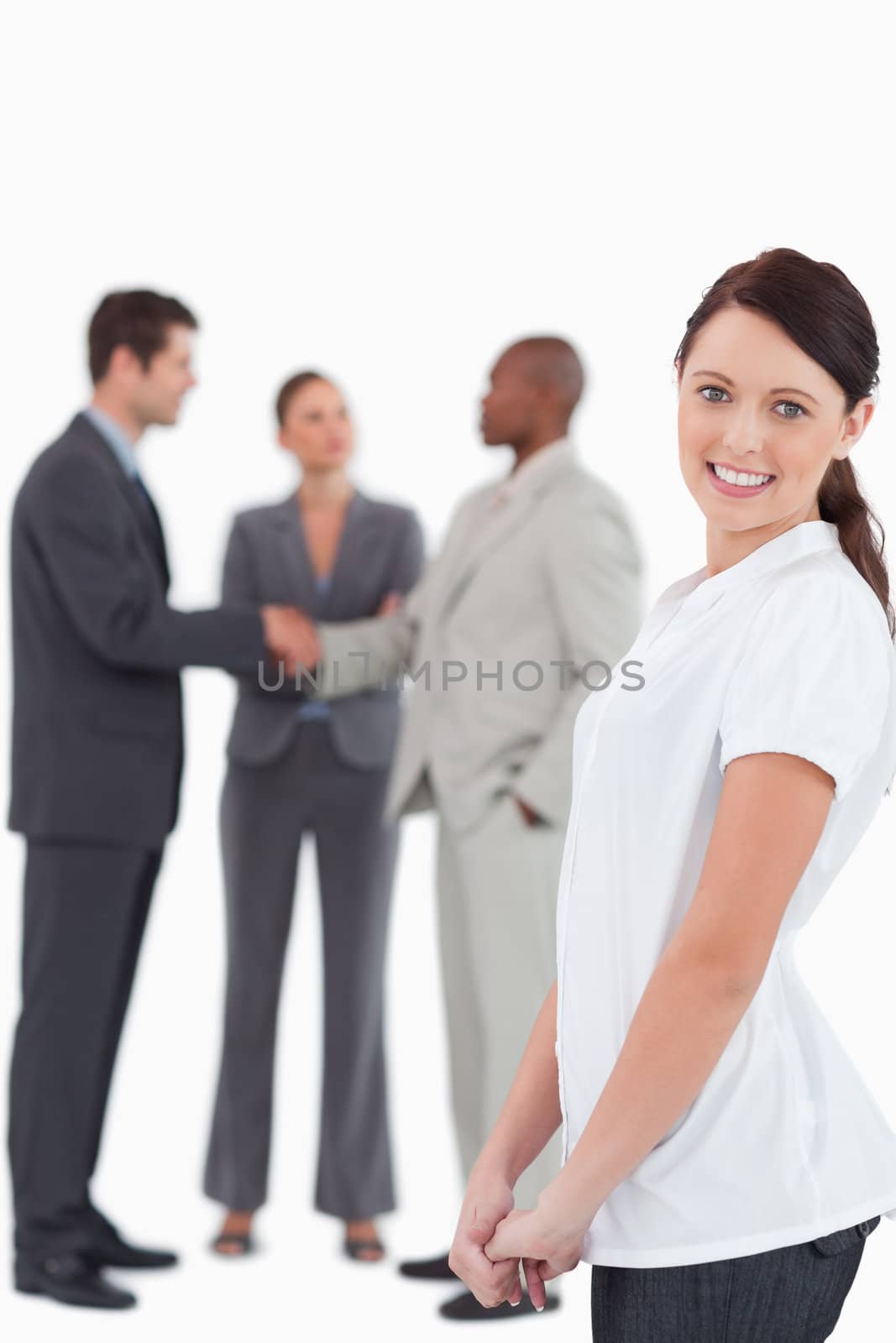 Smiling tradeswoman with three colleagues behind her against a white background