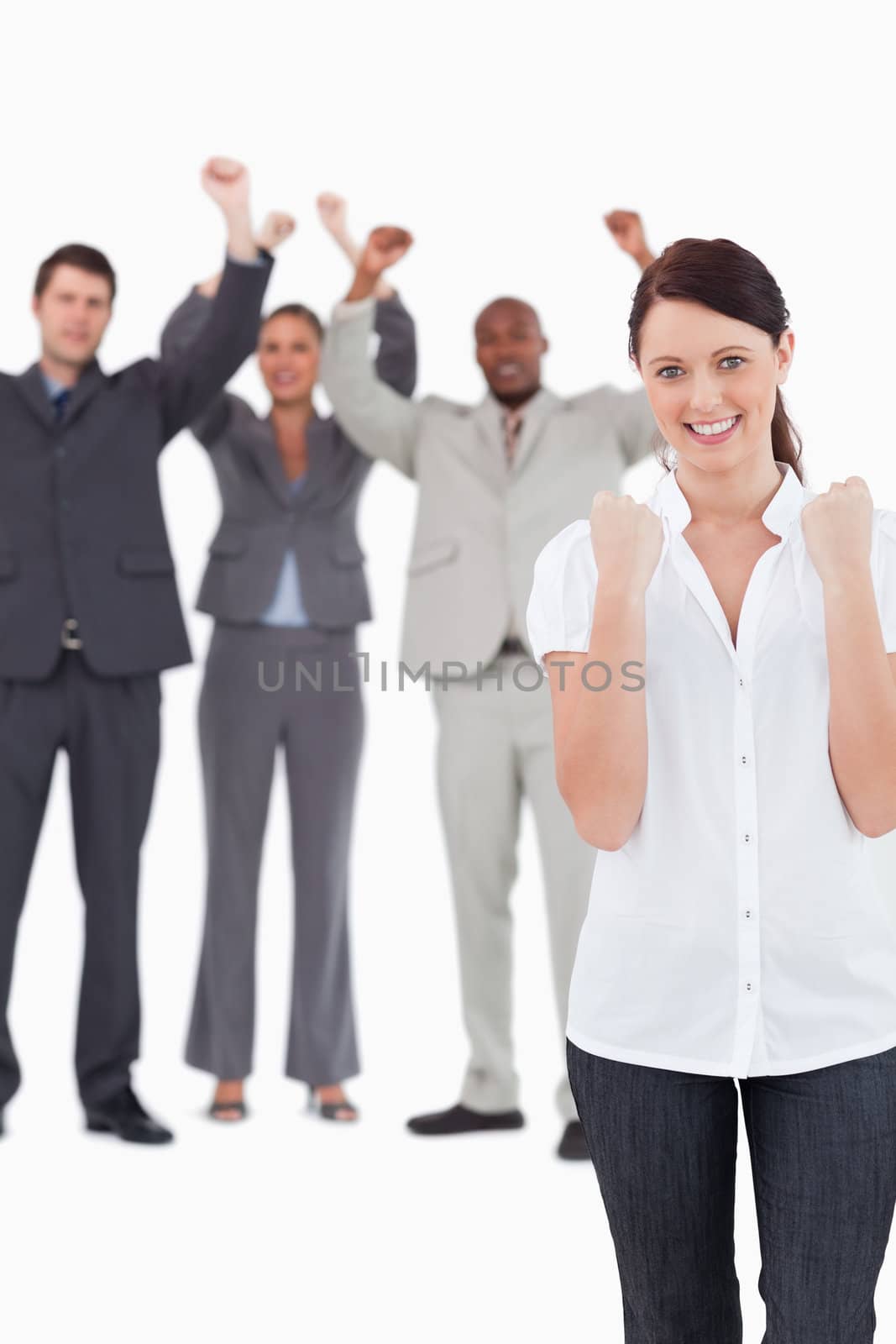 Successful businesswoman with cheering colleagues behind her against a white background