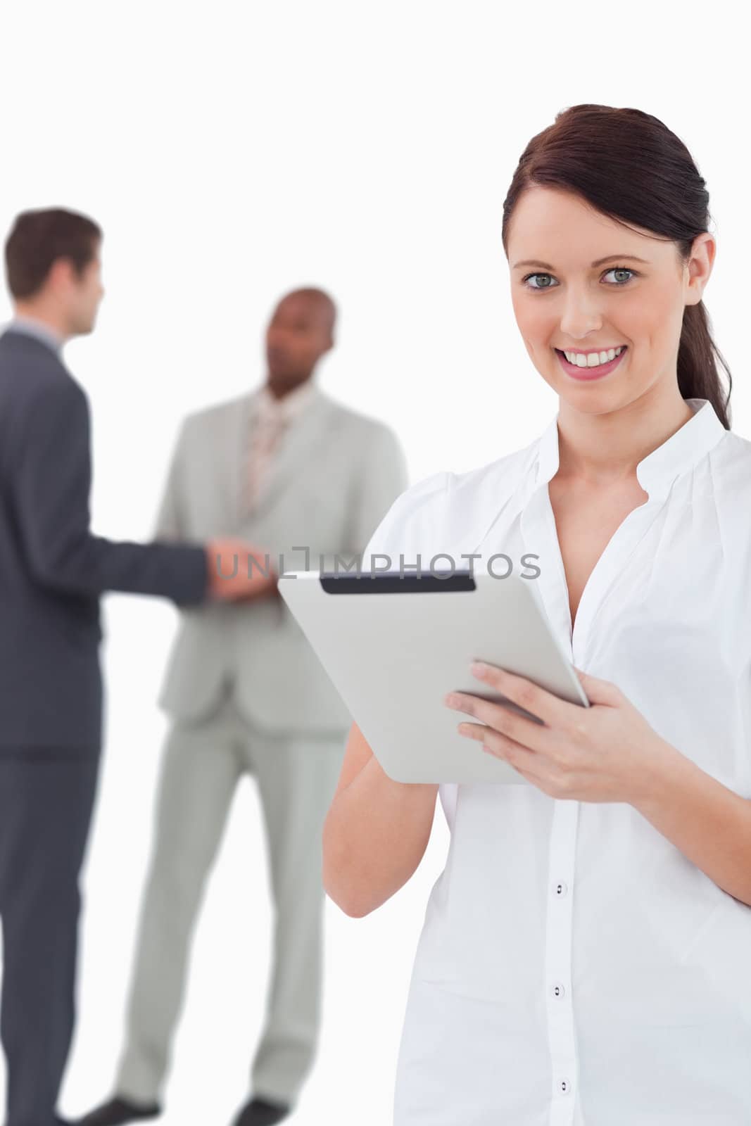 Businesswoman with tablet and associates behind her against a white background