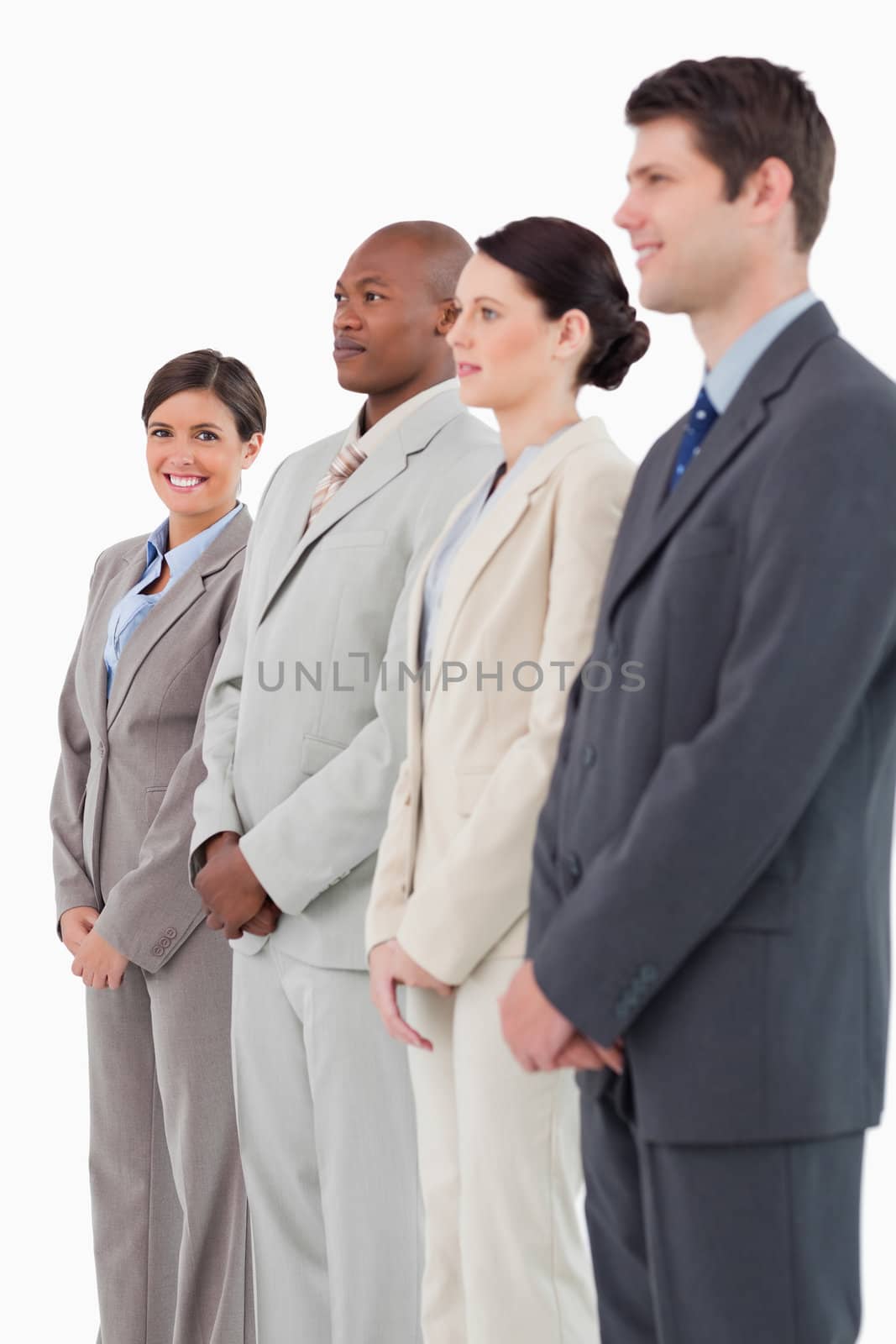 Smiling saleswoman standing next to her colleagues against a white background