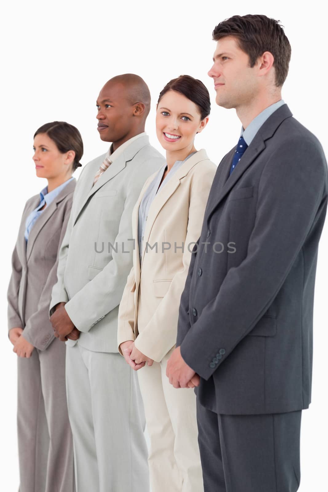 Smiling saleswoman standing between her colleagues against a white background