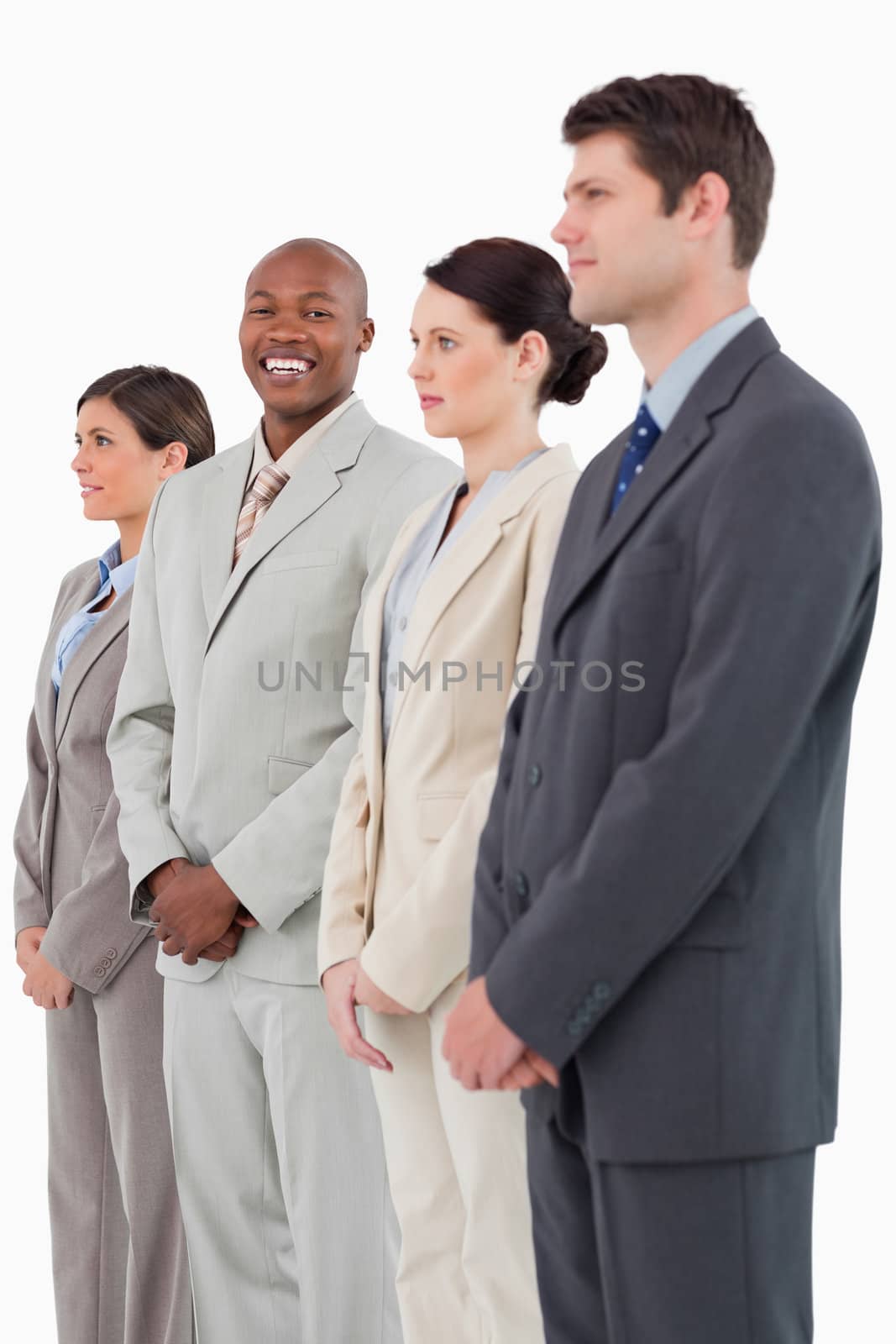 Smiling businessman standing between his colleagues against a white background