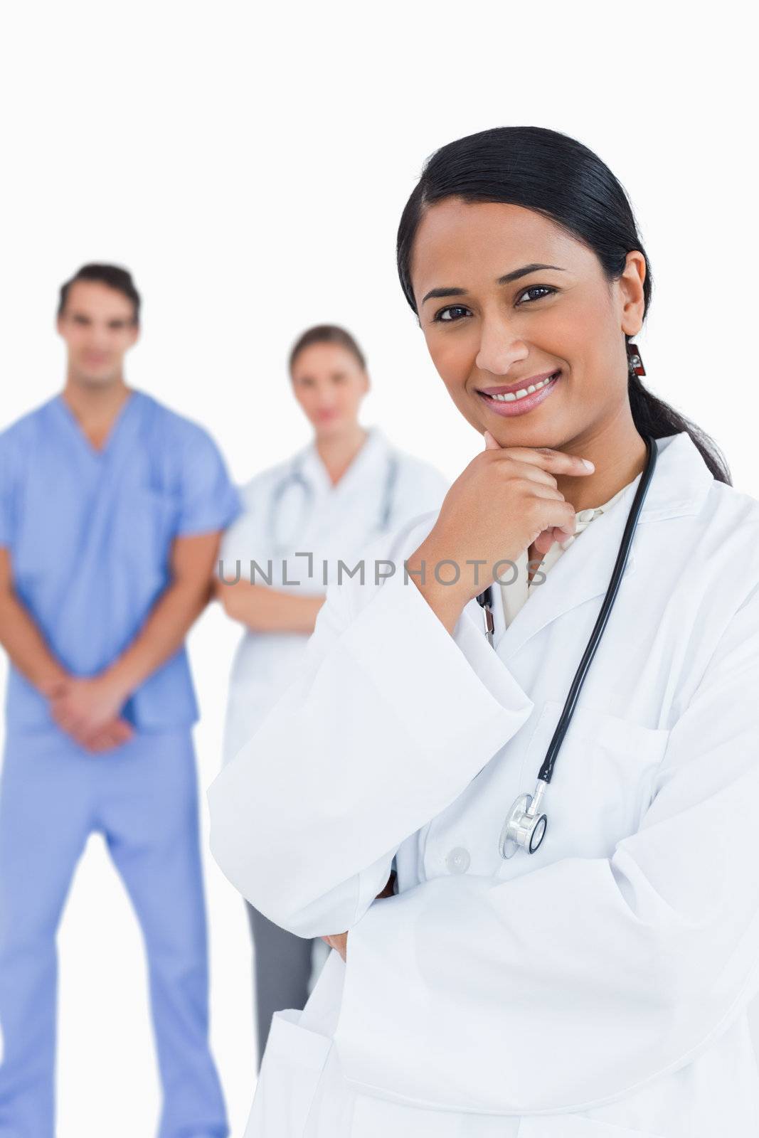 Smiling doctor with staff behind her against a white background