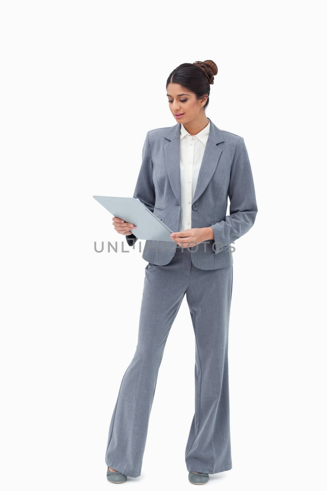 Businesswoman looking at her clipboard against a white background