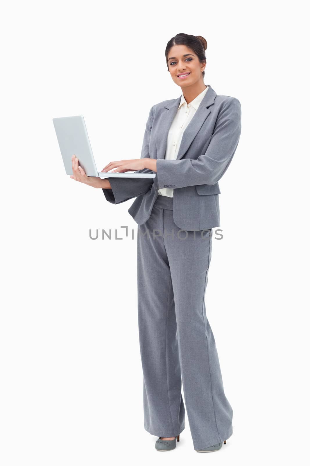 Smiling businesswoman using laptop white standing against a white background
