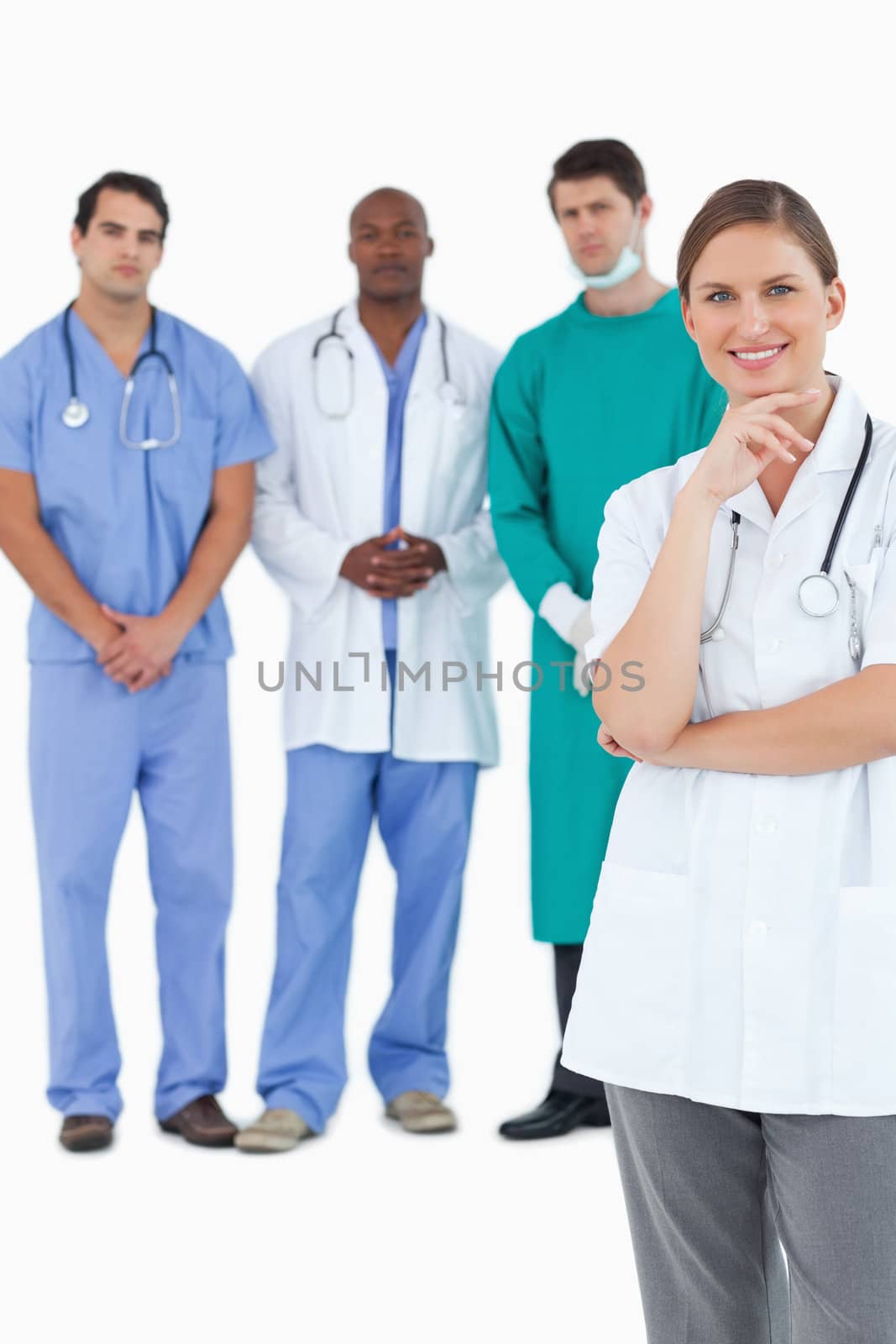 Smiling doctor with male staff members behind her against a white background