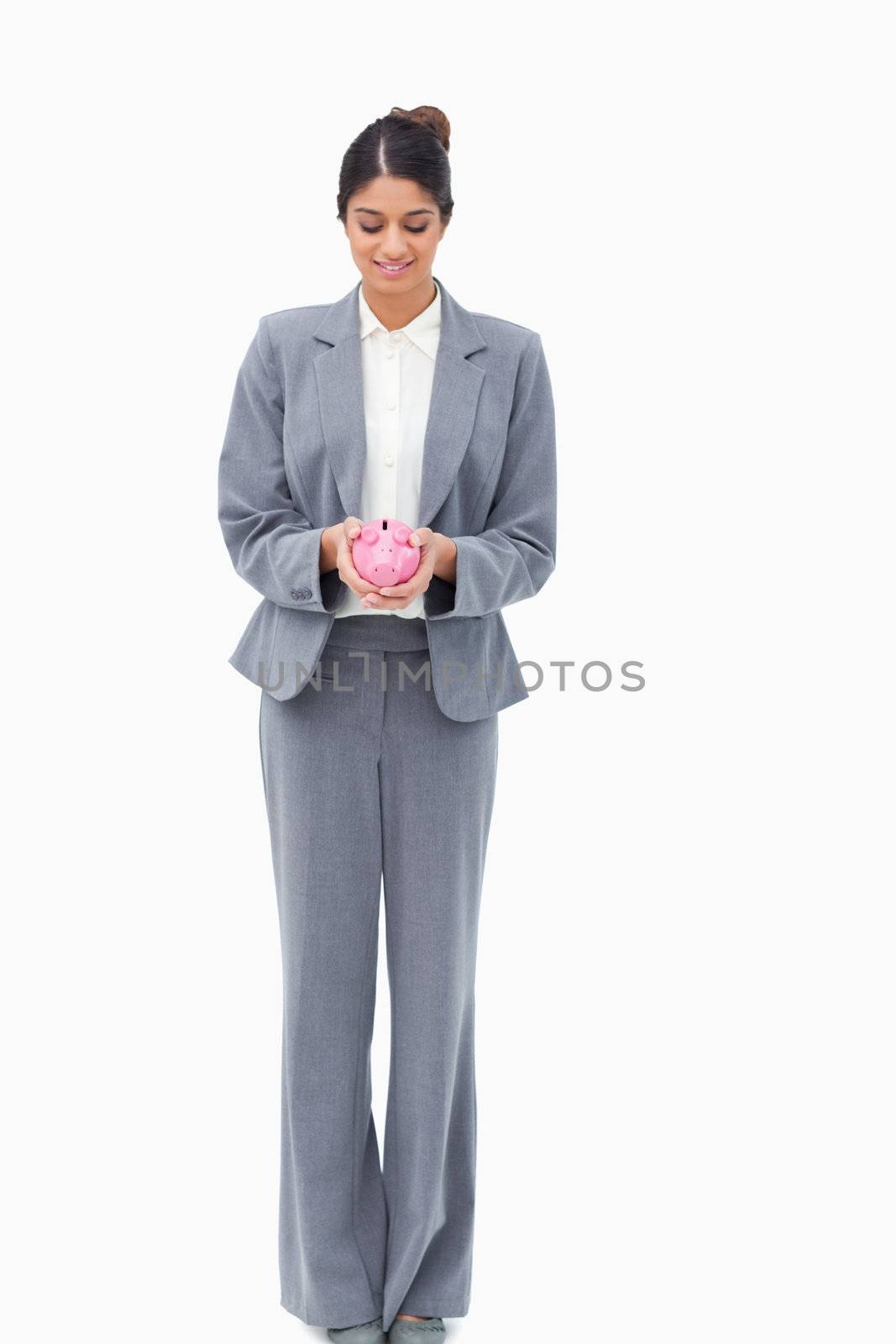 Smiling bank assistant with piggy bank against a white background