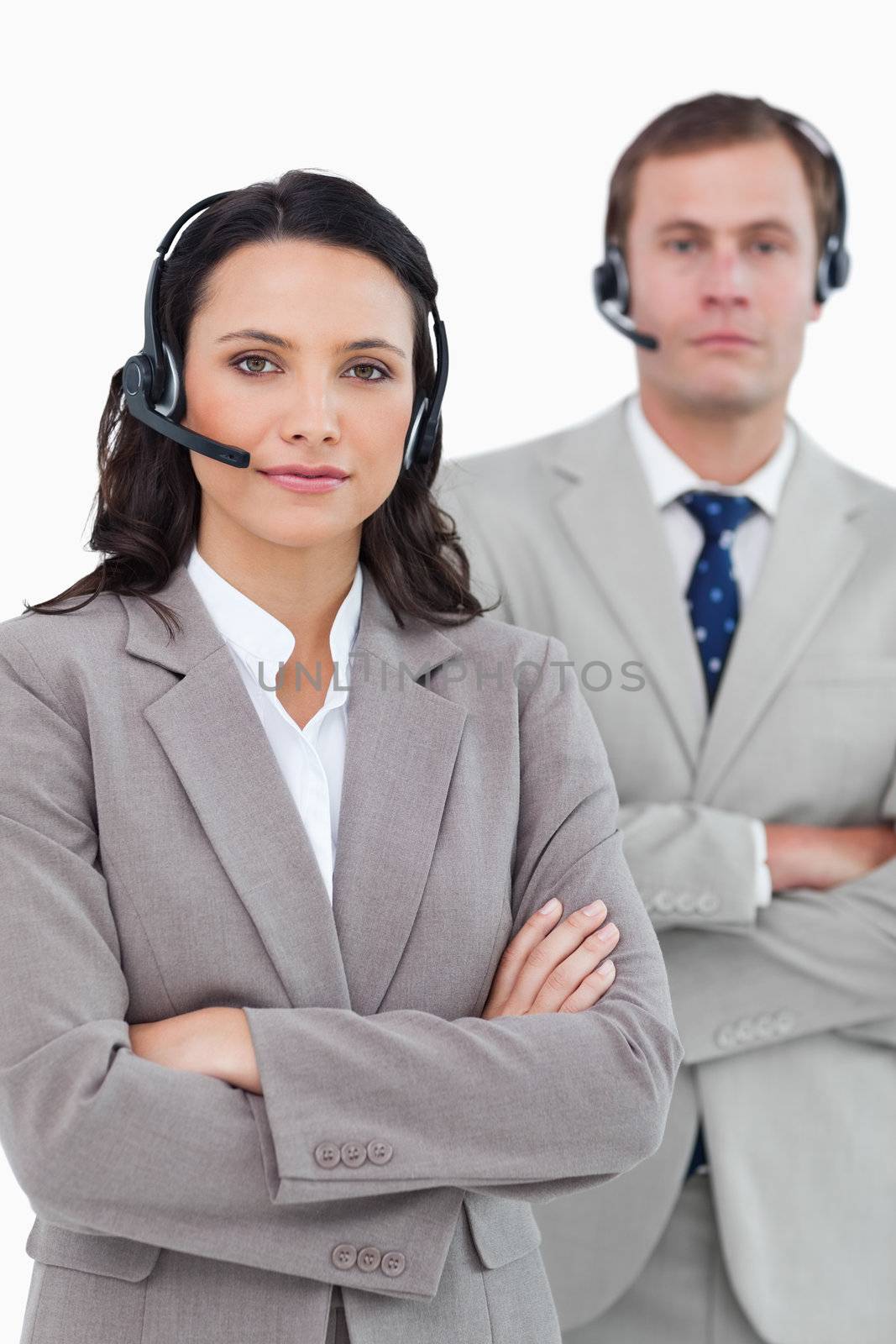 Call center agents with headsets and arms folded against a white background