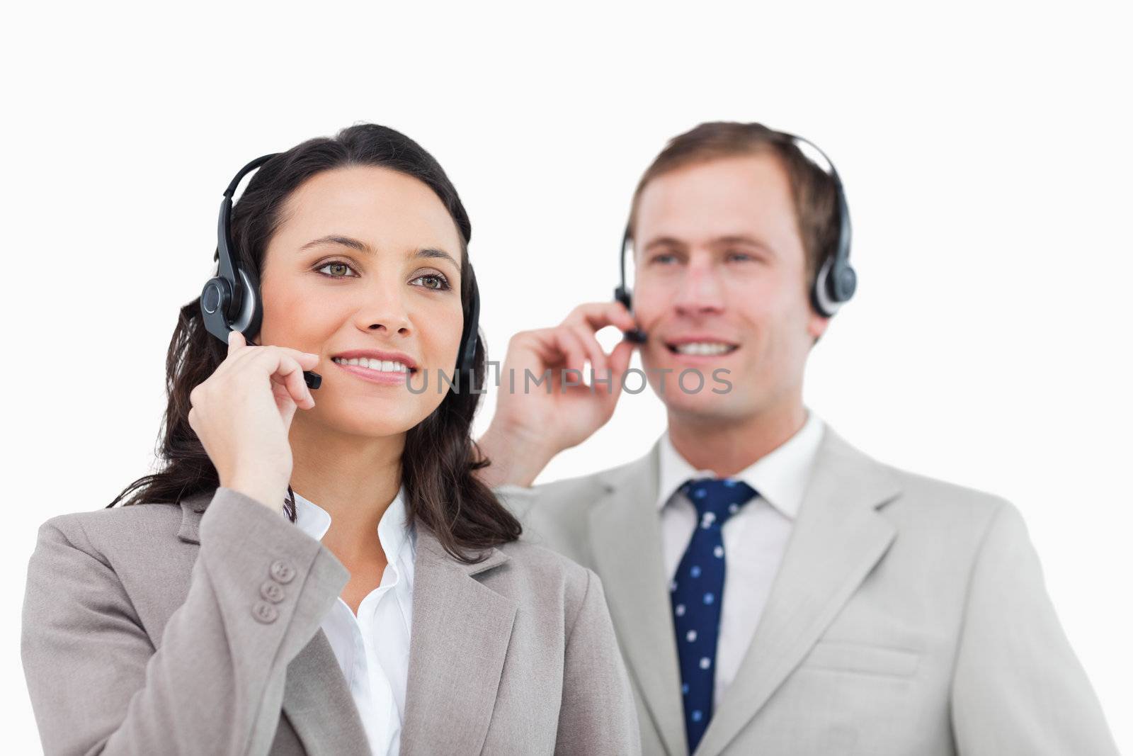 Telephone help desk employees with headsets against a white background