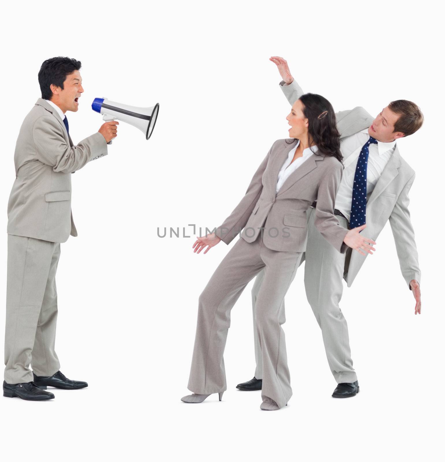 Businessman with megaphone shouting at colleagues against a white background