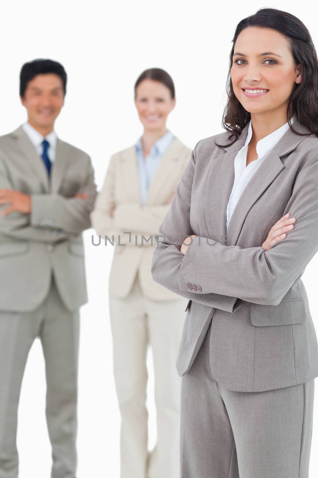 Smiling tradeswoman with folded arms and associates behind her against a white background