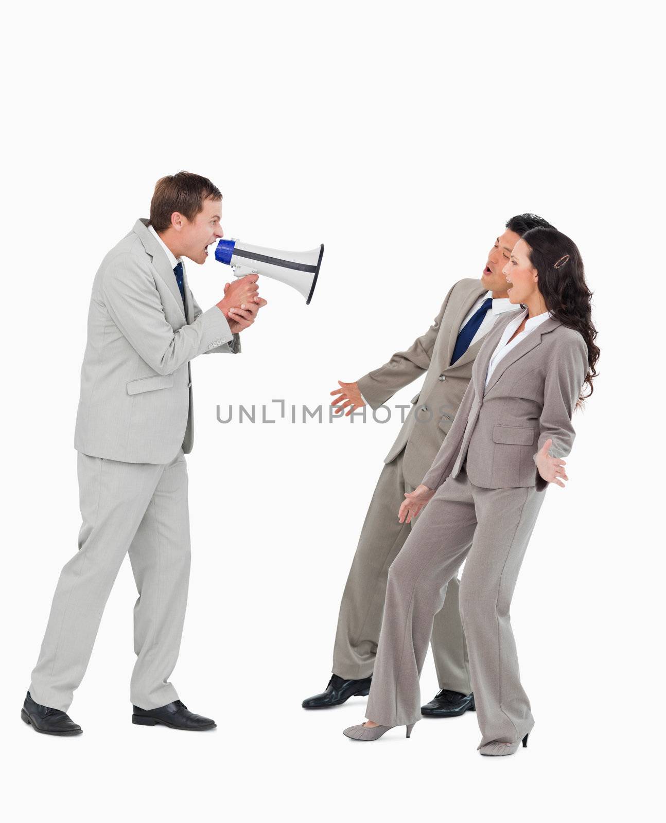 Businessman with megaphone yelling at associates against a white background
