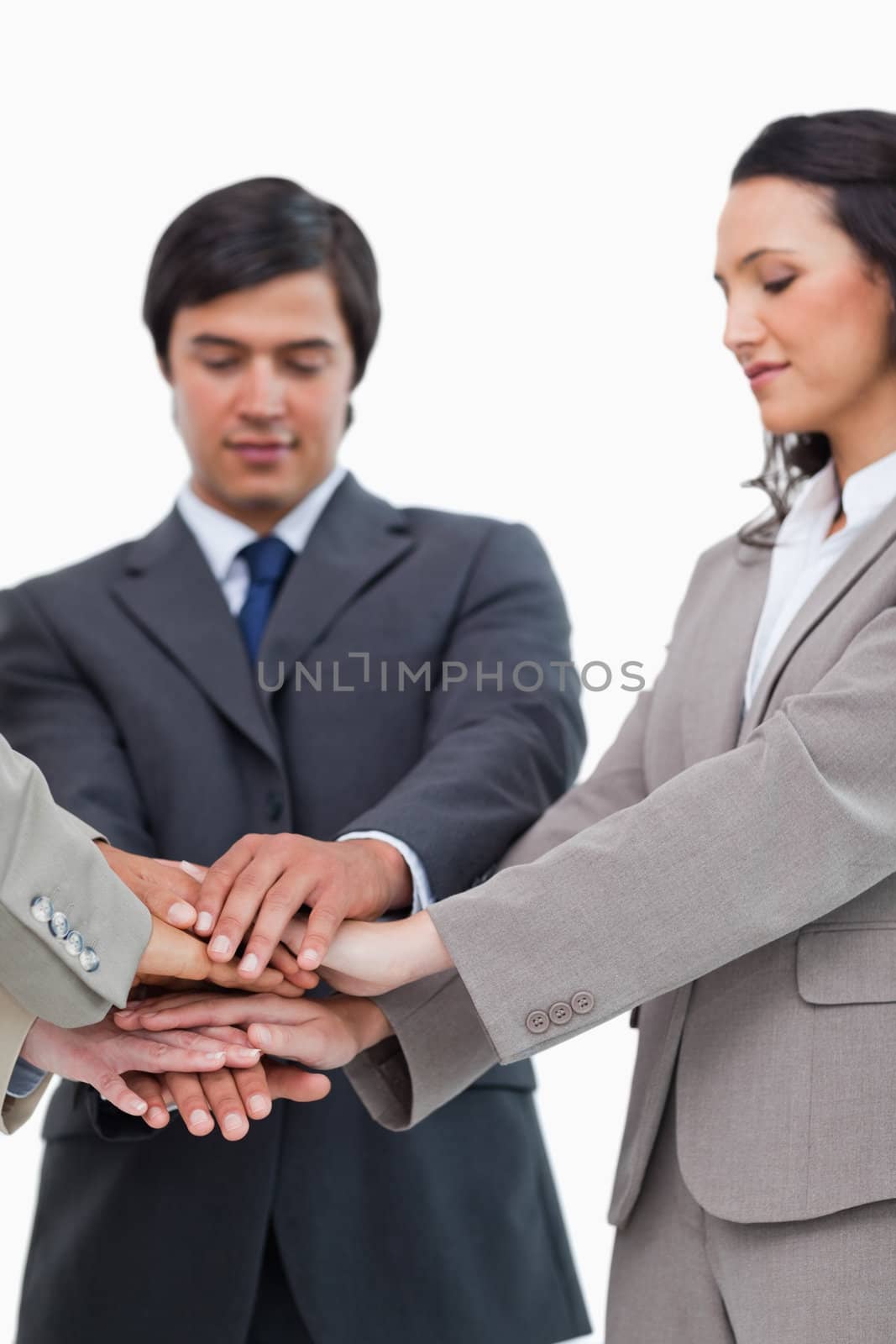 Hands of businesspeople forming a pile against a white background