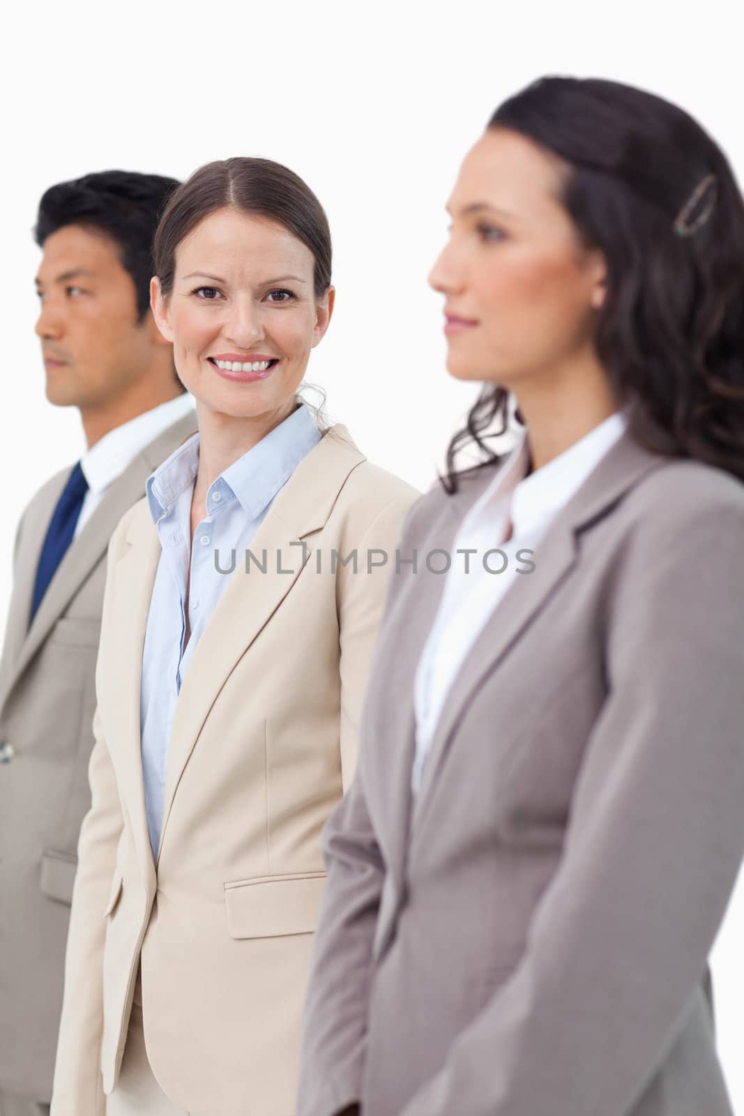 Smiling saleswoman standing between colleagues by Wavebreakmedia