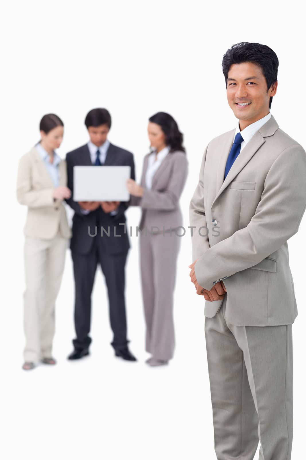 Salesman with colleagues and laptop behind him against a white background