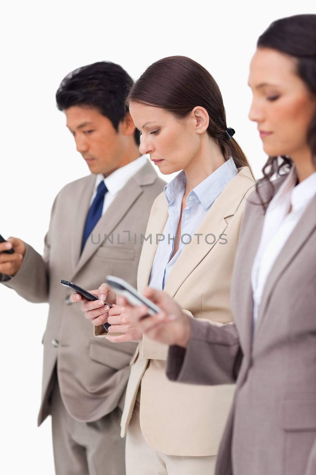 Group of businesspeople with their cellphones against a white background