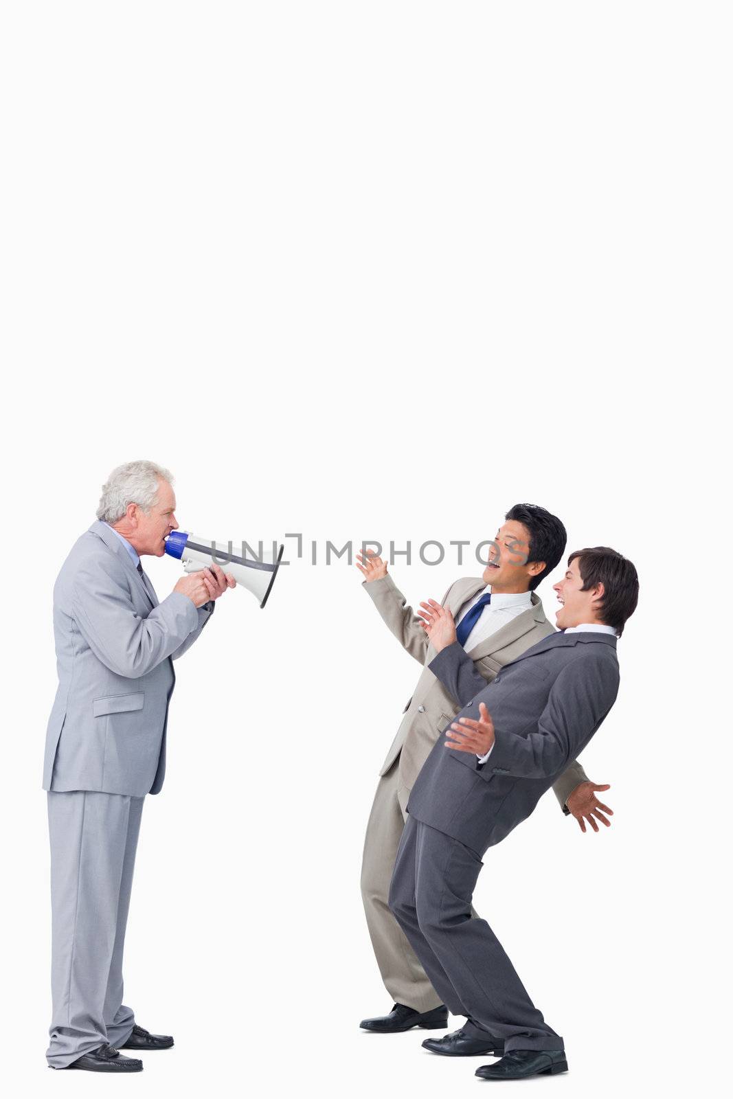 Mature businessman with megaphone yelling at his employees against a white background