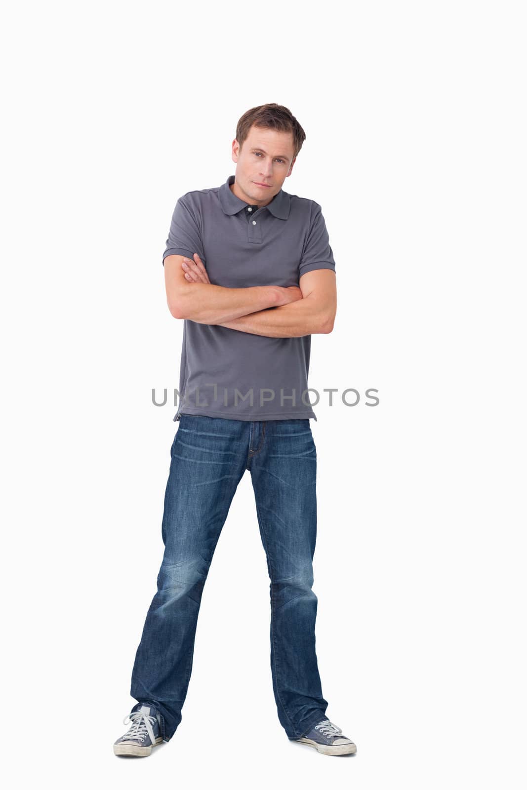 Young man with his arms folded against a white background