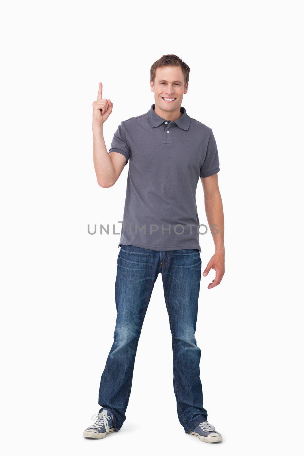 Smiling young man pointing up against a white background