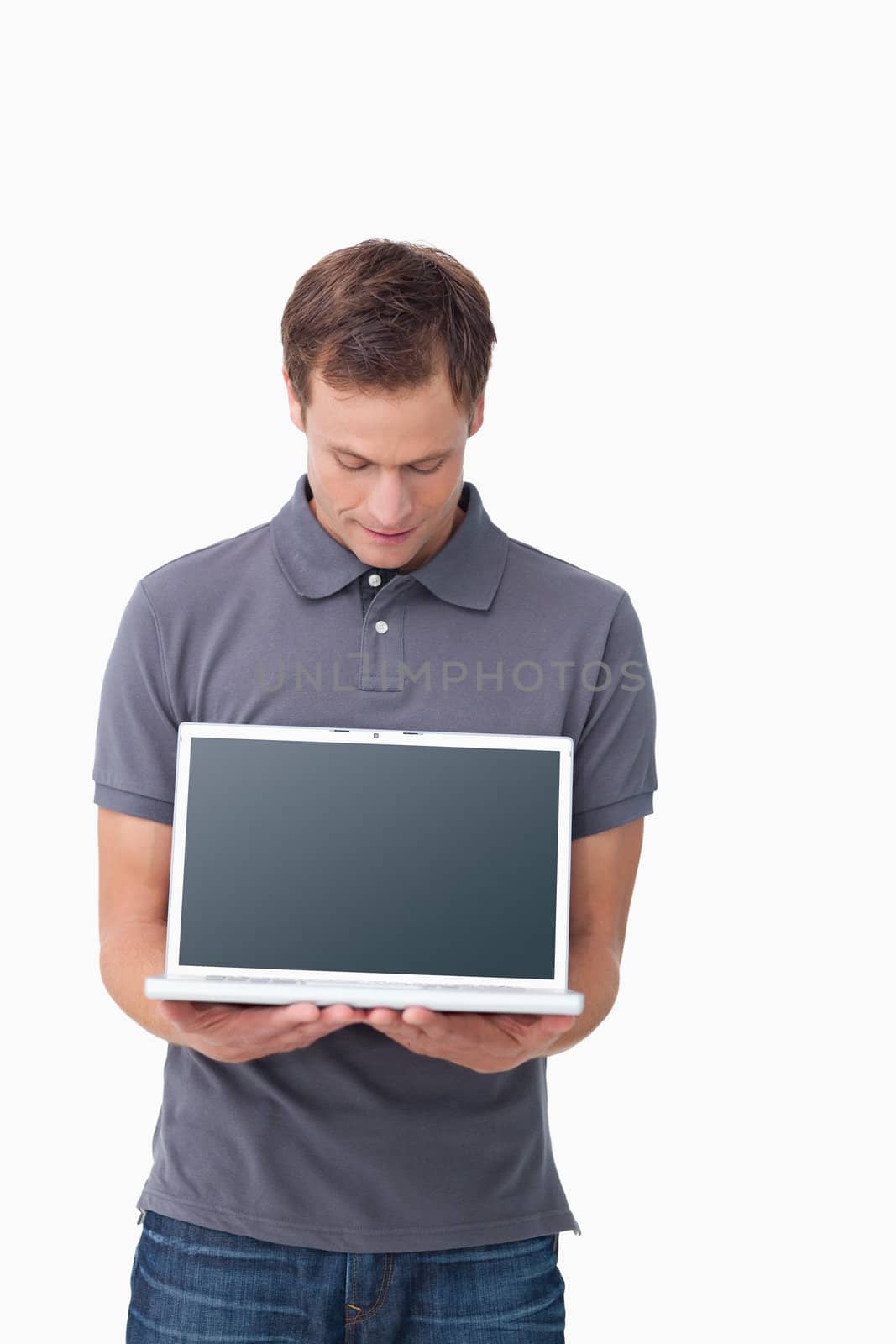Young man showing screen of his notebook against a white background